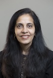 Priya S. Kishnani, Duke University, smiling in dark blazer and dark background with medium length dark hair