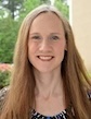 Laura Pollard, PhD, smiles with outdoor setting in background