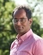 Pranesh Chakraborty, MD, CHEO smiling in pink dress shirt short brown hair and outdoor setting